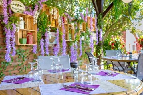 a table with purple napkins and wine glasses on it at Les Pins Blancs en Provence in Le Muy
