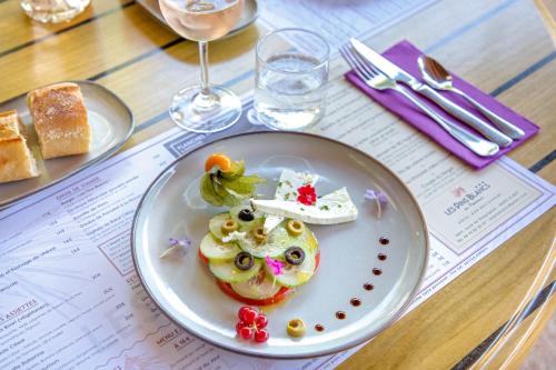 a plate of food on a table with wine glasses at Les Pins Blancs en Provence in Le Muy