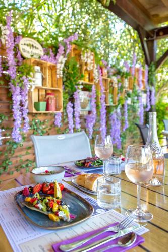 a table with plates of food and glasses of wine at Les Pins Blancs en Provence in Le Muy