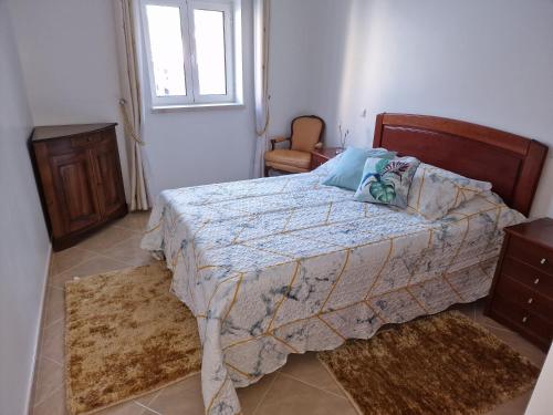 um quarto com uma cama e uma janela em Chez Gilbert-Alojamento Local em Alqueidão da Serra