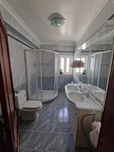 uma casa de banho com um WC, um lavatório e um chuveiro em Chez Gilbert-Alojamento Local em Alqueidão da Serra