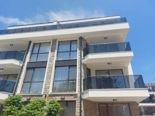 ein Apartmenthaus mit Balkon an der Seite in der Unterkunft Skarabey Park Apartment Sarafovo in Burgas City