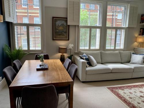 uma sala de estar com uma mesa e um sofá em Lovely newly refurbished apartment in Battersea em Londres