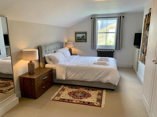 a bedroom with a large bed and a window at Lovely newly refurbished apartment in Battersea in London