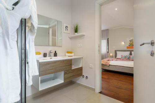 a bathroom with a sink and a bed in a room at Villa Caprice - Krk in Milohnići