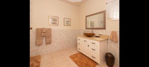 a bathroom with a sink and a mirror at Hills Royale Villa -Ironshore Montego Bay in Montego Bay