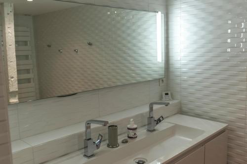 a bathroom with a sink and a large mirror at Gîte du Café Suquet Giroussens in Giroussens
