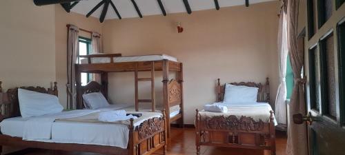 a bedroom with two bunk beds and a window at Hotel Casa San Rafael in Villa de Leyva