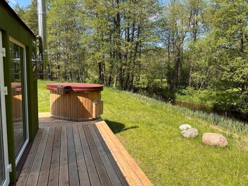 a wooden deck with a bench on the side of a house at ALANTOS ŽIRGAI Holiday Villas sauna or hottube additional price in Alanta