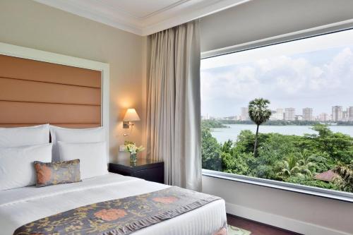 a bedroom with a bed and a large window at Marriott Executive Apartment - Lakeside Chalet, Mumbai in Mumbai