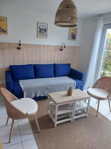 a blue couch in a living room with chairs and tables at Maison 3 piscines - Résidence 3 étoiles in Pornichet