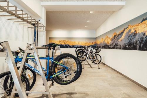 2 bicicletas expuestas en una habitación con montañas en la pared en Naturhotel Feriengut Darrehof, en Serfaus
