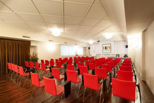 a room with red chairs in a hall at Hotel Lombardia in Milan