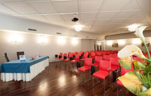 a conference room with red chairs and a table in the middle at Hotel Lombardia in Milan
