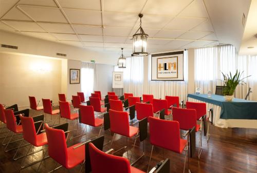 a conference room with red chairs and a table at Hotel Lombardia in Milan