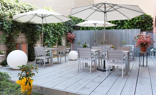 a patio with tables and chairs and umbrellas at Hotel Lombardia in Milan