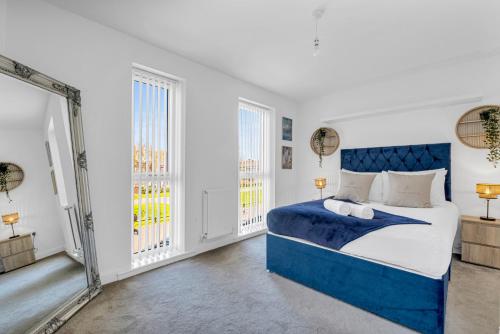 ein Schlafzimmer mit einem blauen Bett und einem Spiegel in der Unterkunft City Centre 3 Bedroom House - Family & Business in Birmingham