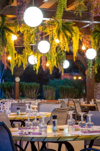a dining room with tables and chairs and lights at Les Pins Blancs en Provence in Le Muy