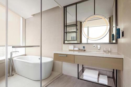 a bathroom with a tub and a sink and a mirror at Four Points by Sheraton Hong Kong, Tung Chung in Hong Kong