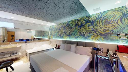 1 dormitorio con 1 cama blanca y un mural en Motel DUBAI BH, en Belo Horizonte