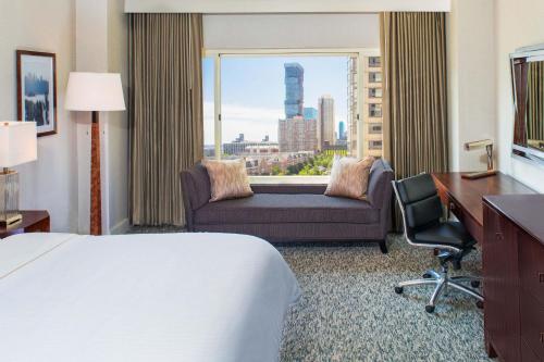 a hotel room with a bed and a desk and a window at The Westin Jersey City Newport in Jersey City