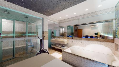 a bathroom with a tub and a large mirror at Motel DUBAI BH in Belo Horizonte