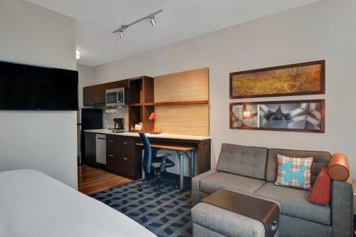 a hotel room with a bed and a couch and a desk at TownePlace Suites by Marriott Indianapolis Downtown in Indianapolis