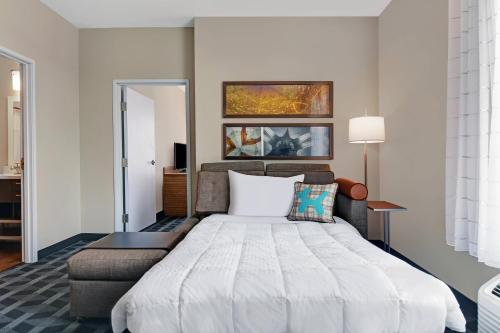 a bedroom with a large bed and a lamp at TownePlace Suites by Marriott Indianapolis Downtown in Indianapolis