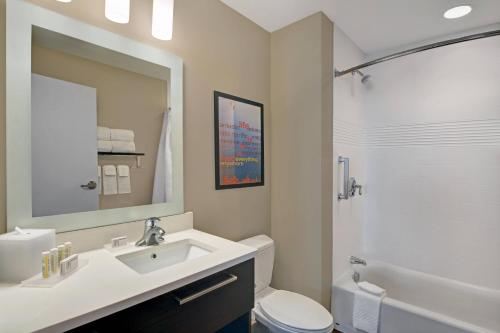 a bathroom with a sink and a toilet and a mirror at TownePlace Suites by Marriott Indianapolis Downtown in Indianapolis