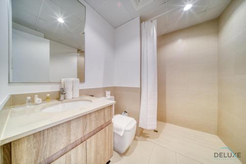 a bathroom with a sink and a toilet and a mirror at Sleek Studio at UNA Town Square Dubailand by Deluxe Holiday Homes in Dubai