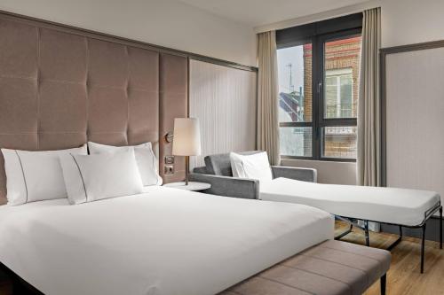 um quarto de hotel com uma cama grande e uma janela em AC Hotel Avenida de América by Marriott em Madri