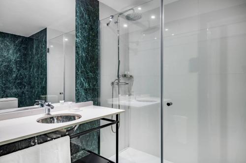 W łazience znajduje się umywalka i prysznic. w obiekcie AC Hotel Avenida de América by Marriott w Madrycie