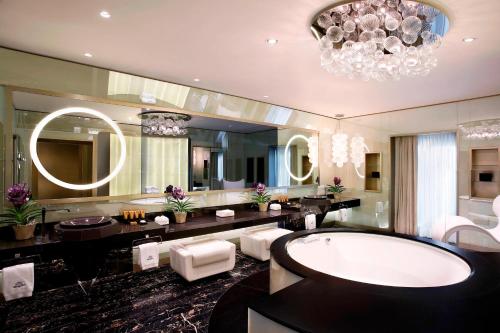 a bathroom with a tub and a large mirror at Excelsior Hotel Gallia, a Luxury Collection Hotel, Milan in Milan