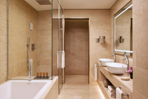 a bathroom with a tub and two sinks and a shower at Excelsior Hotel Gallia, a Luxury Collection Hotel, Milan in Milan
