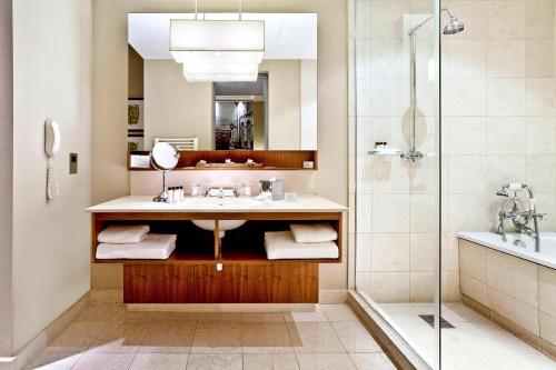 a bathroom with a sink and a shower at Threadneedles, Autograph Collection in London