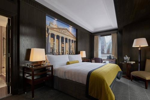 a hotel room with a large bed and a window at Threadneedles, Autograph Collection in London