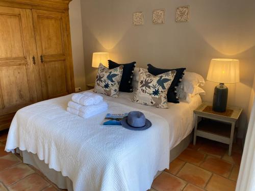 a bedroom with a bed with towels and a hat on it at Pretty Historical Village House in Grimaud