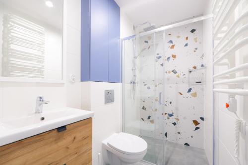 biała łazienka z toaletą i prysznicem w obiekcie Telimeny 31 w Krakowie