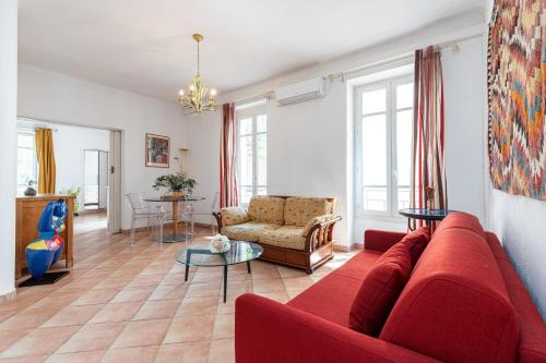 un salon avec un canapé rouge et une table dans l'établissement Large 2 Bdr Downtown - AC & Terrace, à Nice