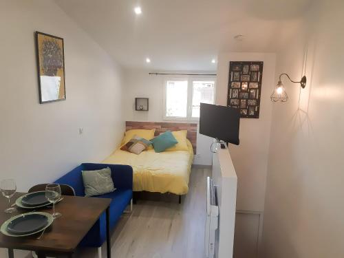 um pequeno quarto com uma cama, uma mesa e um sofá em Studio Meublé très Agréable em Pessac