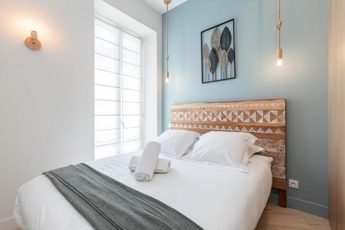 une chambre avec un lit avec des draps blancs et des oreillers dans l'établissement Charming Central 1 Bdr, à Nice