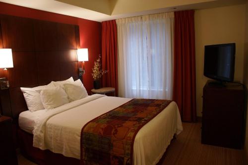 a hotel room with a bed and a television at Residence Inn Pittsburgh Monroeville/Wilkins Township in Monroeville