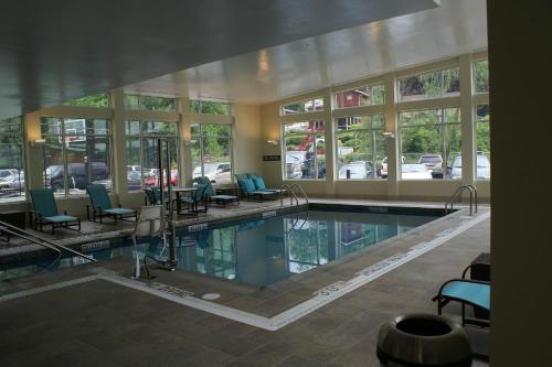 una piscina en un edificio con sillas y ventanas en Residence Inn Pittsburgh Monroeville/Wilkins Township, en Monroeville