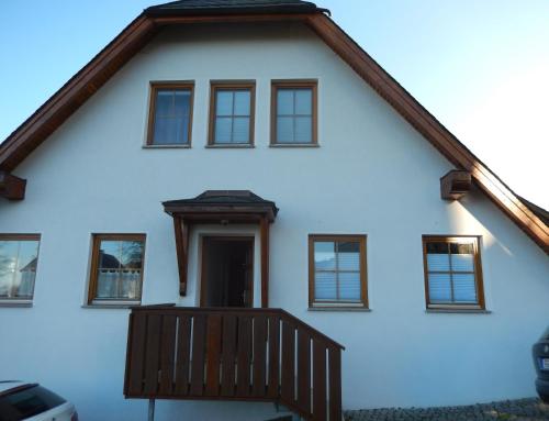 a white house with a porch and windows at Zum Elleblick in Frauenstein