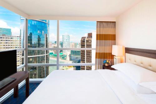 a hotel room with a bed and a large window at Sheraton Vancouver Wall Centre in Vancouver