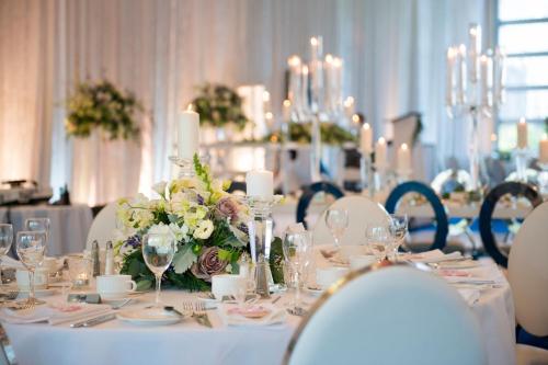 a dining room with a table with flowers and candles at Sheraton Vancouver Wall Centre in Vancouver