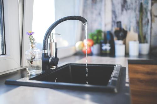 a kitchen sink with water running from a faucet at Apartamenty Delux-S1 przy trasie S1 in Łodygowice