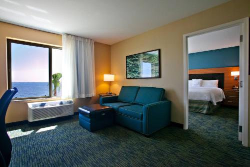 um quarto de hotel com uma cadeira azul e uma cama em TownePlace Suites by Marriott Fort Walton Beach-Eglin AFB em Fort Walton Beach