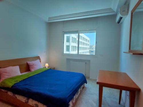 a bedroom with a blue bed and a window at luxe & VIP appartement a côté de tunsia mall lac 2 in Tunis