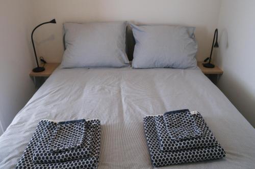 ein Bett mit zwei Kissen und zwei Körben darauf in der Unterkunft Seepaertje 2 in Noordwijk aan Zee